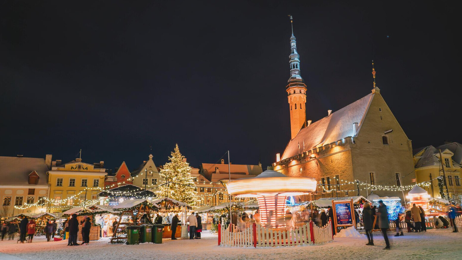 Stimmungsvoller Weihnachtsmarkt in Tallinn am Abend mit festlich beleuchteten Ständen in der historischen Altstadt.